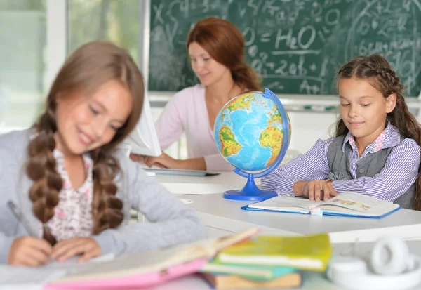 Lehrerin mit zwei Mädchen im Unterricht — Stockfoto