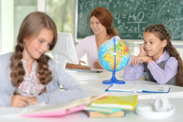 Lehrerin mit zwei Mädchen im Unterricht — Stockfoto