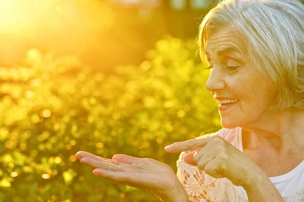 Senior woman showing something — Stock Photo, Image