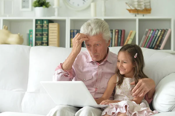 孫のいる老人は家でノートパソコンを使って — ストック写真