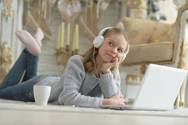 Ragazza Cuffia Utilizzando Computer Portatile Mentre Sdraiato Sul Pavimento — Foto Stock