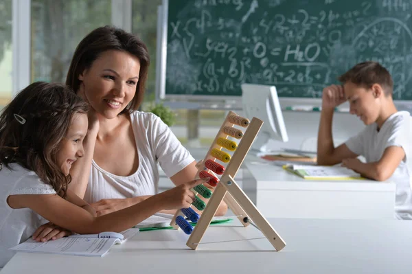 Vrouw Onderwijs Meisje Naar Gebruik Abacus Binnen — Stockfoto