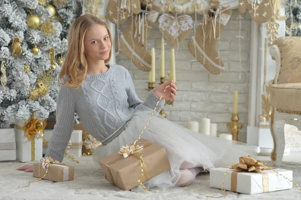 圣诞时带着礼物坐着的女孩的画像 — 图库照片
