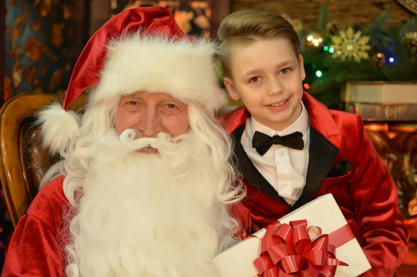 圣诞老人和带着礼物的快乐男孩 — 图库照片