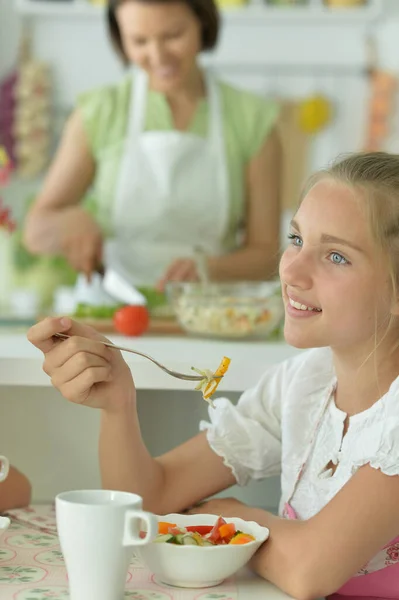 漂亮的女孩在厨房里吃沙拉 — 图库照片