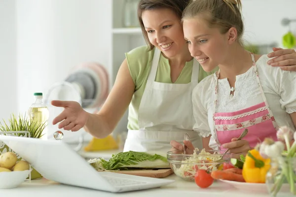 Flicka Med Sin Mamma Matlagning Tillsammans Vid Köksbordet Tittar Laptop — Stockfoto