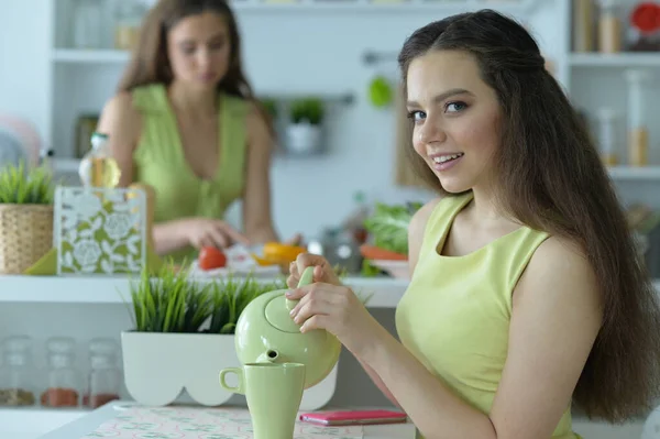 ティーン女の子座っていますホワイトテーブルと飲み物茶 — ストック写真