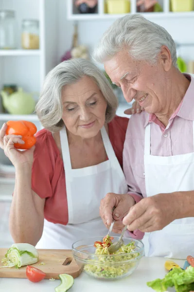 快乐的老夫妇在厨房一起做沙拉 — 图库照片