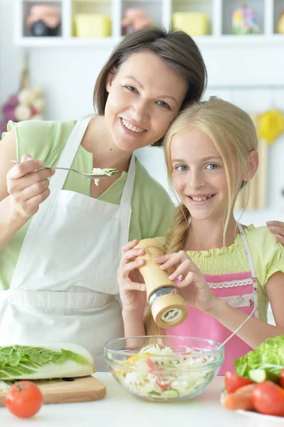 可愛いです女の子とともに彼女のお母さん料理とともにキッチンテーブル — ストック写真