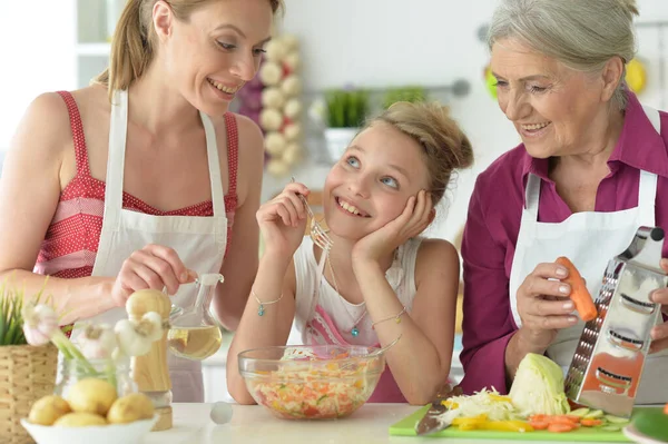 Söt Flicka Med Mor Och Mormor Förbereder Läcker Färsk Sallad — Stockfoto