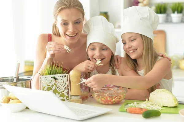 Милые Девушки Мамой Готовят Вкусный Свежий Салат Кухне Глядя Ноутбук — стоковое фото