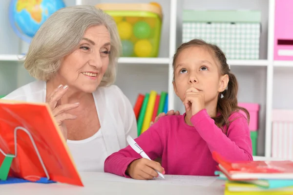 Porträtt Liten Flicka Som Gör Läxor Med Sin Mormor Hemma — Stockfoto