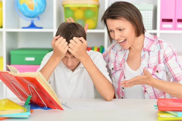感情的な母親とともに彼女の息子は家で宿題をする — ストック写真