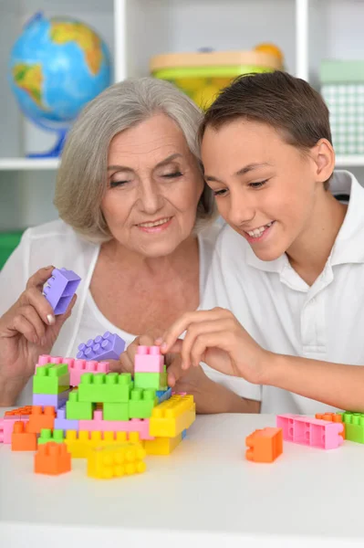 Lächelnder Junge Spielt Mit Großmutter Mit Bunten Plastikklötzen — Stockfoto