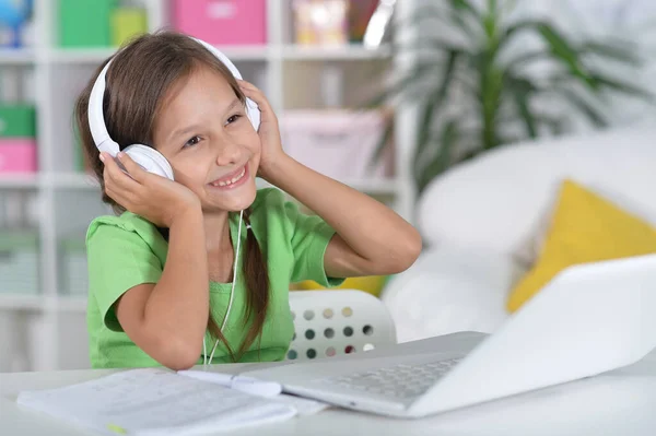 Schattig Meisje Hoofdtelefoon Met Behulp Van Laptop Thuis Aan Balie — Stockfoto