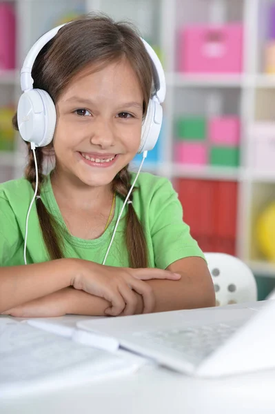 Schattig Meisje Hoofdtelefoon Met Behulp Van Laptop Thuis Aan Balie — Stockfoto