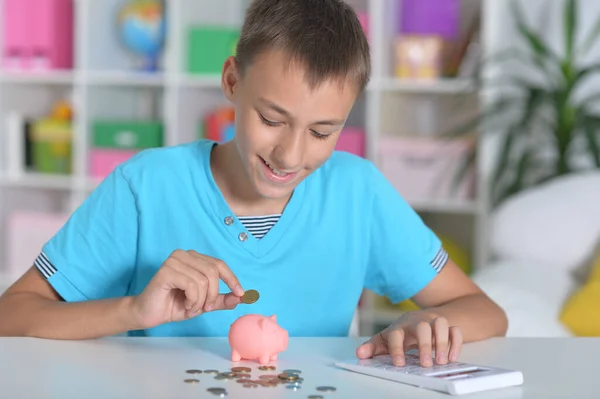 Cute Boy Pitting Coins Piggy Bank While Sitting Table — Stock Photo, Image