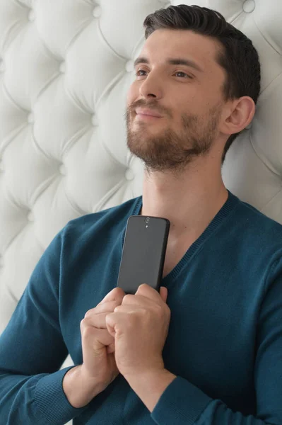 Joven Guapo Sosteniendo Teléfono Inteligente —  Fotos de Stock