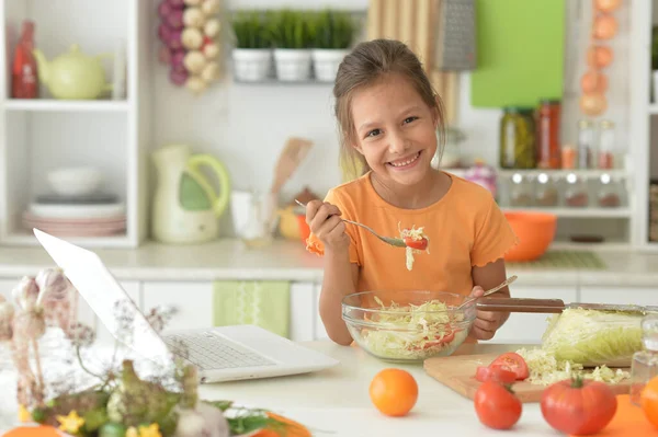 Söt Flicka Gör Sallad Kök Och Använda Laptop — Stockfoto