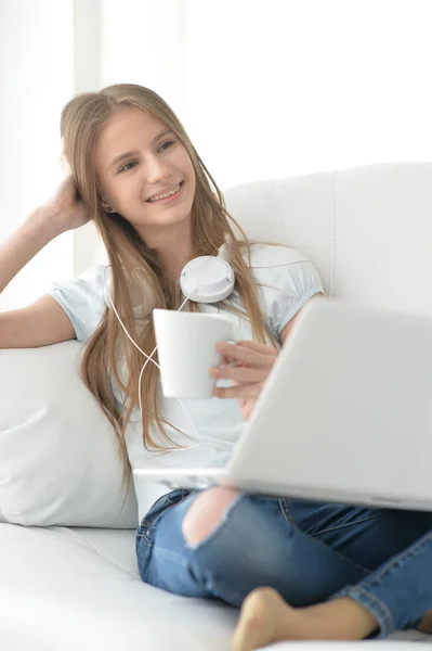 Χαριτωμένο Κορίτσι Ακουστικά Χρησιμοποιώντας Φορητό Υπολογιστή Στον Καναπέ Στο Σπίτι — Φωτογραφία Αρχείου