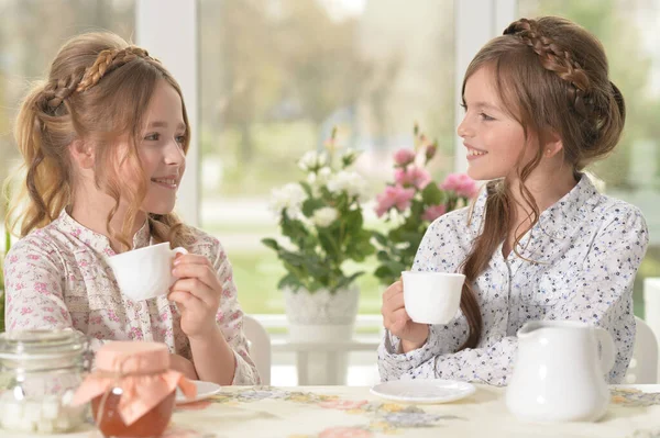 Zwei Lächelnde Kleine Mädchen Die Hause Tee Trinken — Stockfoto