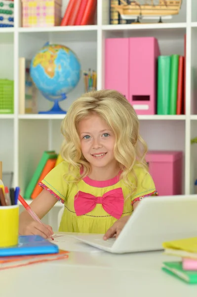 漂亮的女孩在家里的书桌上用笔记本电脑 — 图库照片