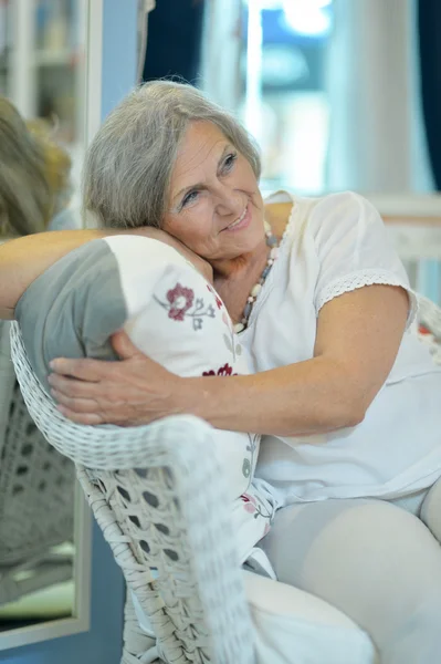 Mature woman sitting in vintage sofa — Stock Photo, Image