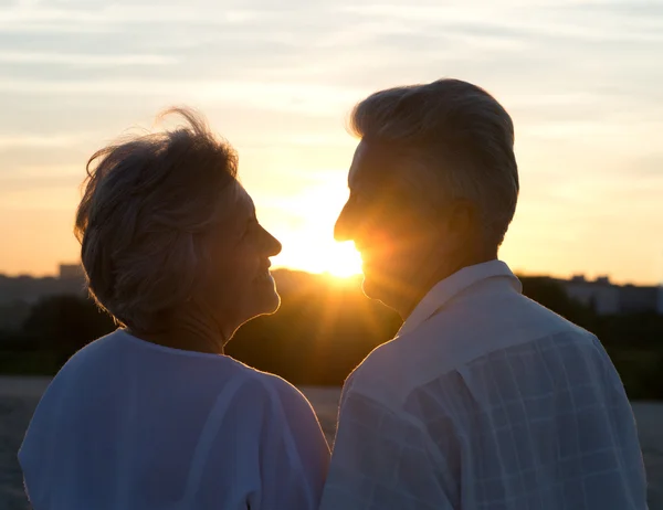 老夫妇俩在日落时分的爱 — 图库照片