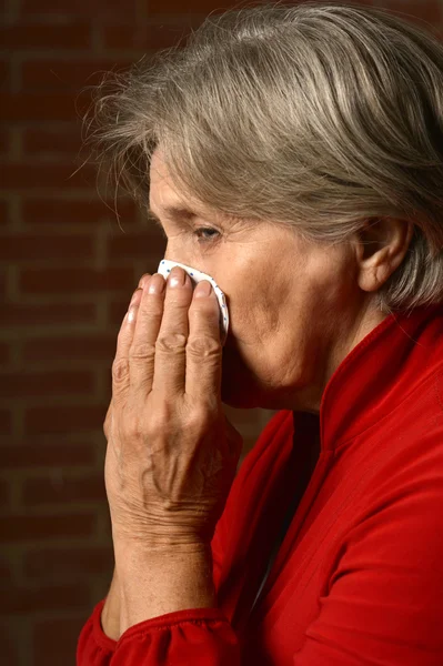 Sick elder woman in red — Stock Photo, Image