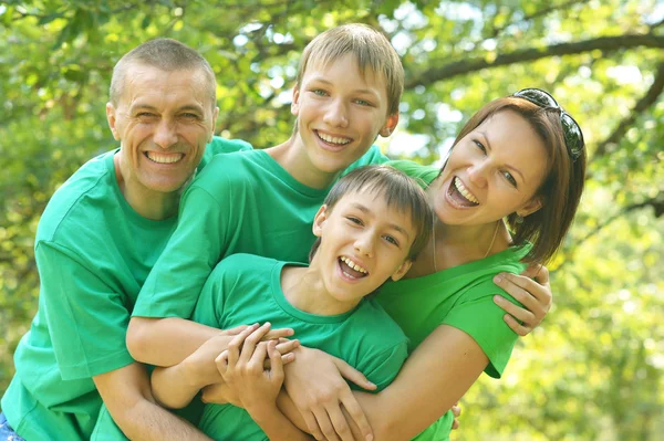 Fröhliche Familie in grünen Hemden — Stockfoto