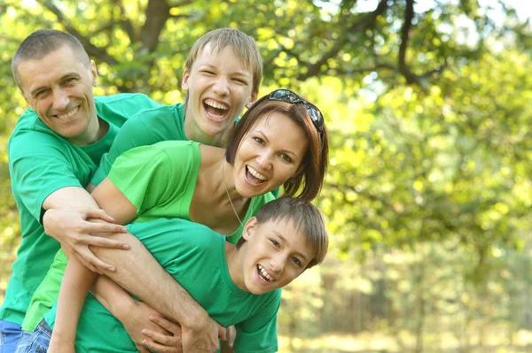 Familia alegre en camisas verdes — Foto de Stock