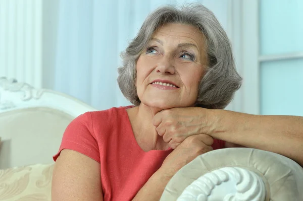 Mature woman sitting in vintage sofa — Stock Photo, Image