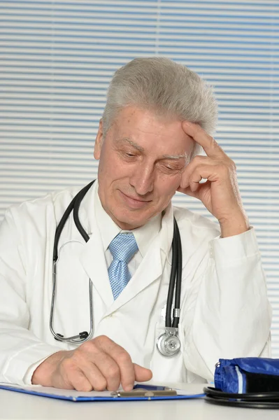 Médico de edad avanzada en la mesa — Foto de Stock