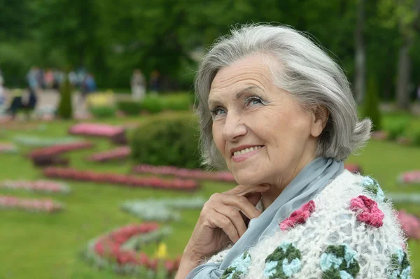 Senior happy woman on walk in summer park — Stock Photo, Image