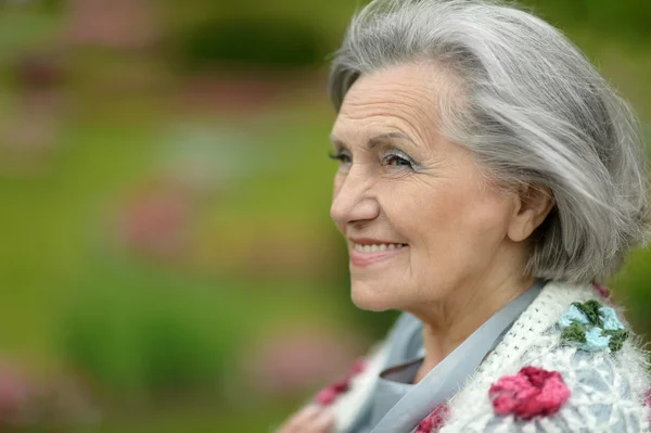 Старшая счастливая женщина на прогулке в летнем парке — стоковое фото