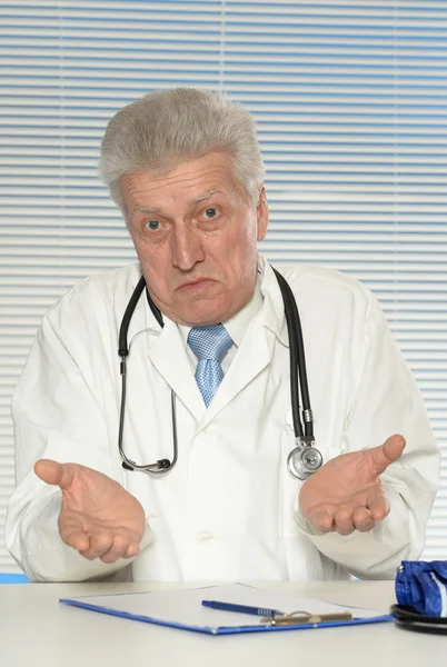 Elderly doctor at table — Stock Photo, Image