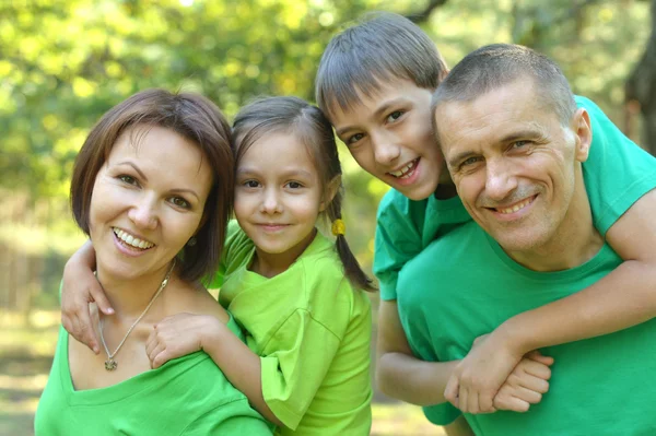 Fröhliche Familie in grünen Hemden — Stockfoto