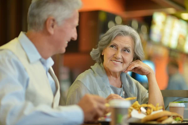 Pareja madura comiendo papas fritas — Foto de Stock