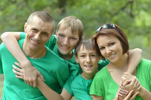 Fröhliche Familie in grünen Hemden — Stockfoto