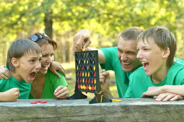 Felice famiglia in camicie verdi giocare — Foto Stock