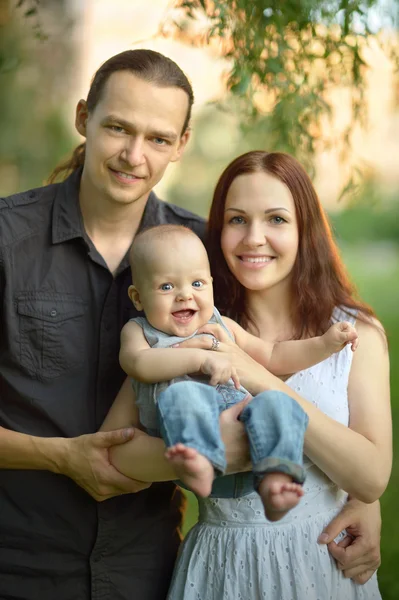 Happy family  holding  son in the park — Stock Photo, Image