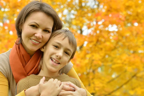 Mamma med en son i höst park — Stockfoto