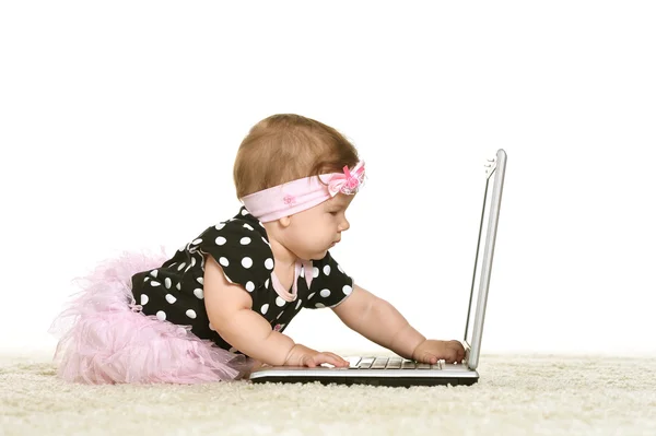 Baby girl is playing with laptop — Stock Photo, Image