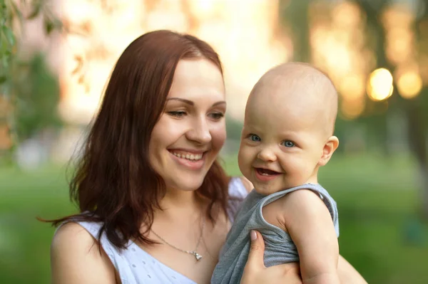 Madre sosteniendo a un hijo pequeño en el parque — Foto de Stock