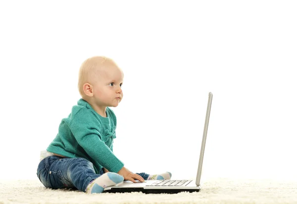 Blond baby girl is playing with laptop — Stock Photo, Image