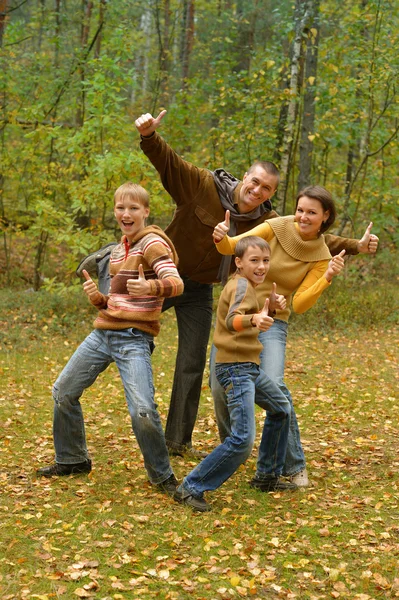 Family show thumbs up in autumn park — Stock Photo, Image