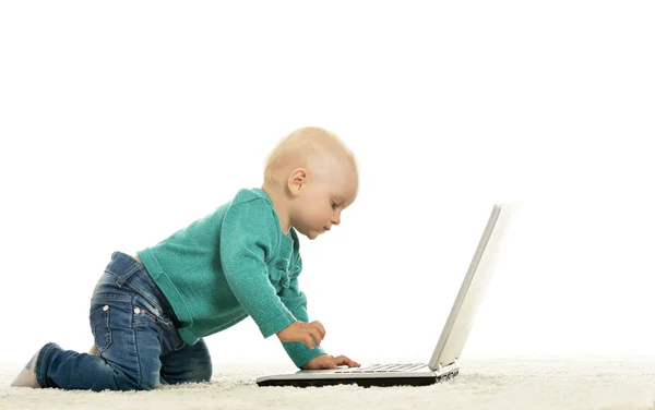 Blond baby girl is playing with laptop — Stock Photo, Image