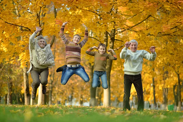 Bejaarde echtpaar en kinderen springen — Stockfoto