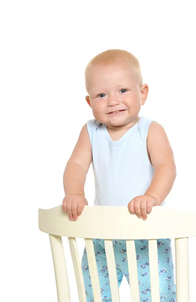 Niño sonriendo y de pie en la silla —  Fotos de Stock
