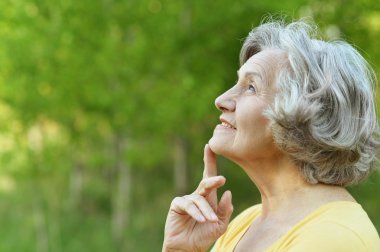 Thinking old woman in the autumn park clipart